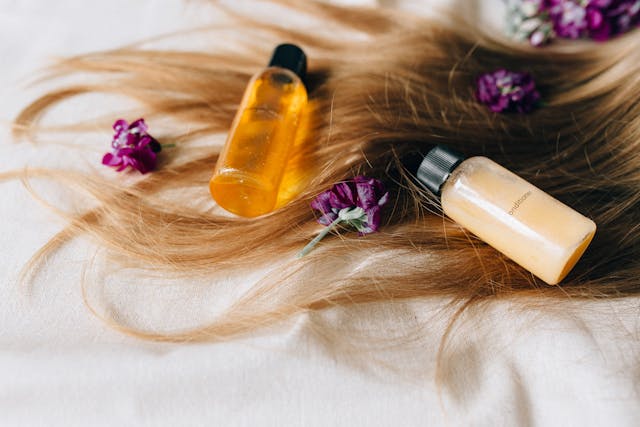 woman applying black seed oil for hair growth with scalp massage healthy shiny hair