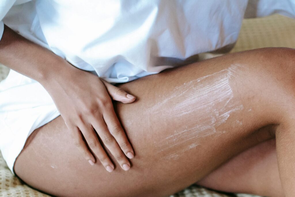 person applying soothing cream to itchy rash inner thigh area for skin relief