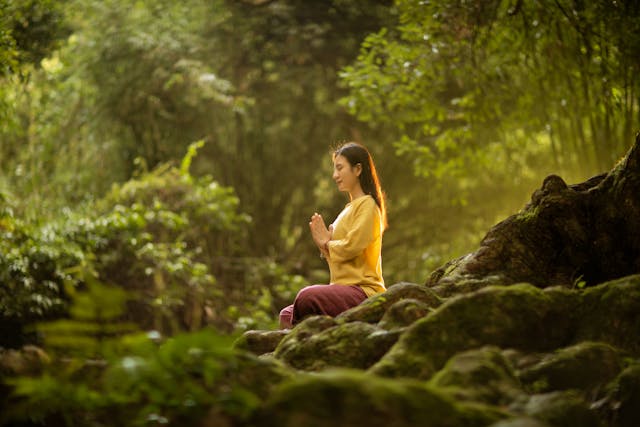 woman practising nervous system reset breathing technique in nature feeling calm and peaceful