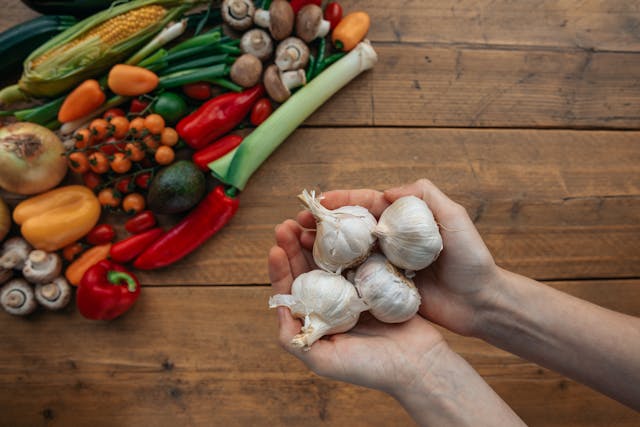 prebiotic foods including garlic onions asparagus and oats on a wooden board