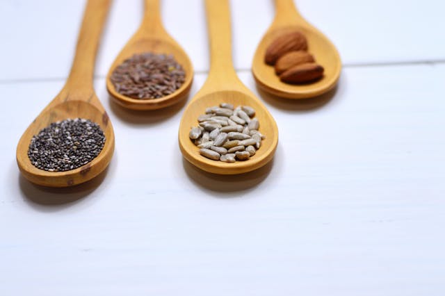 four bowls of seed cycling seeds including flaxseeds pumpkin sesame and sunflower seeds
