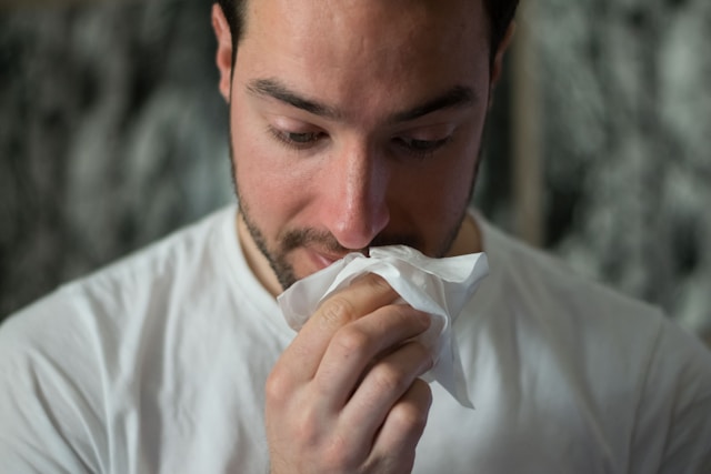 person blowing nose into tissue snot color meaning health indicator